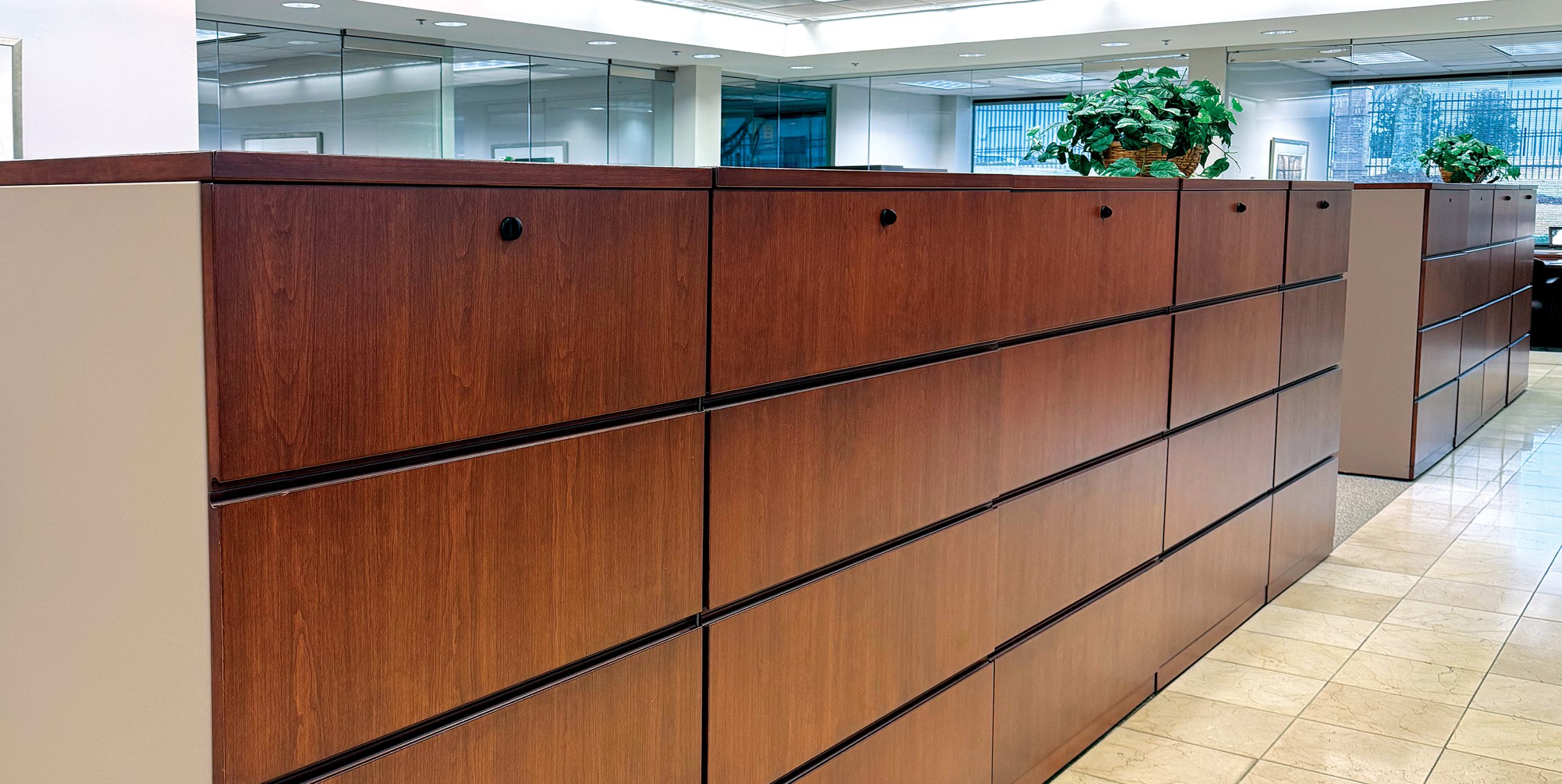 long bank of filing cabinets in an office setting; these drawers have the anti-tip system installed, to ensure they do not fall over on top of the user